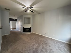 Open spacious family room with a cozy fireplace and opening above for a TV or decorating in this Decatur townhome for rent.