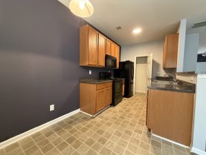 Kitchen view from breakfast area featuring accent wall in Decatur townhome for rent.